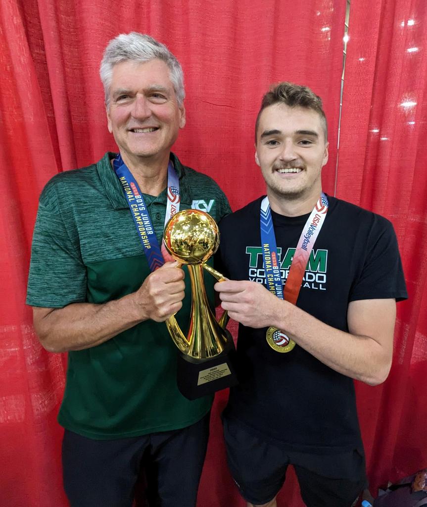 Marco Dewey and Tom holding a championship trophy